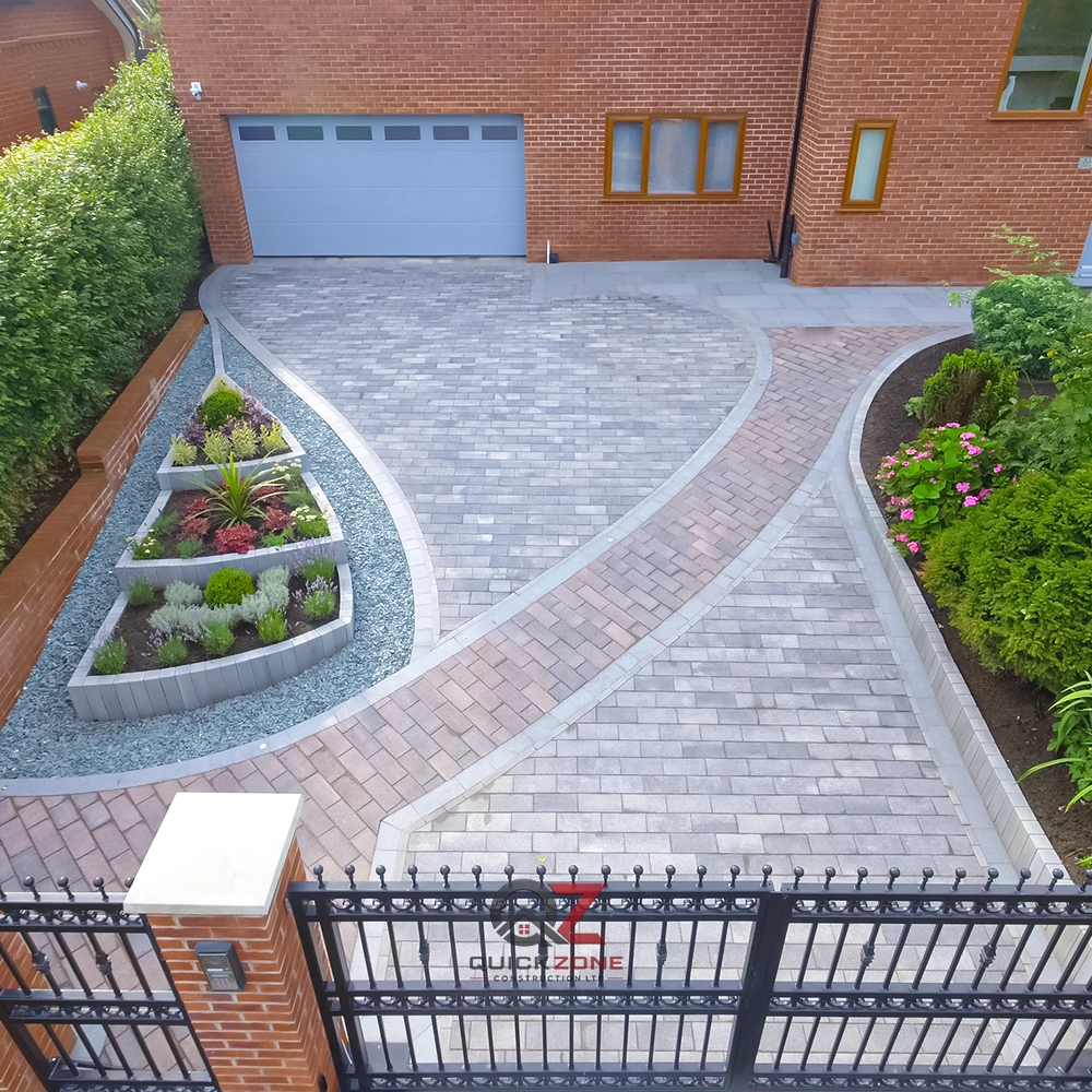 patterned block paved driveway with curved design and planted borders